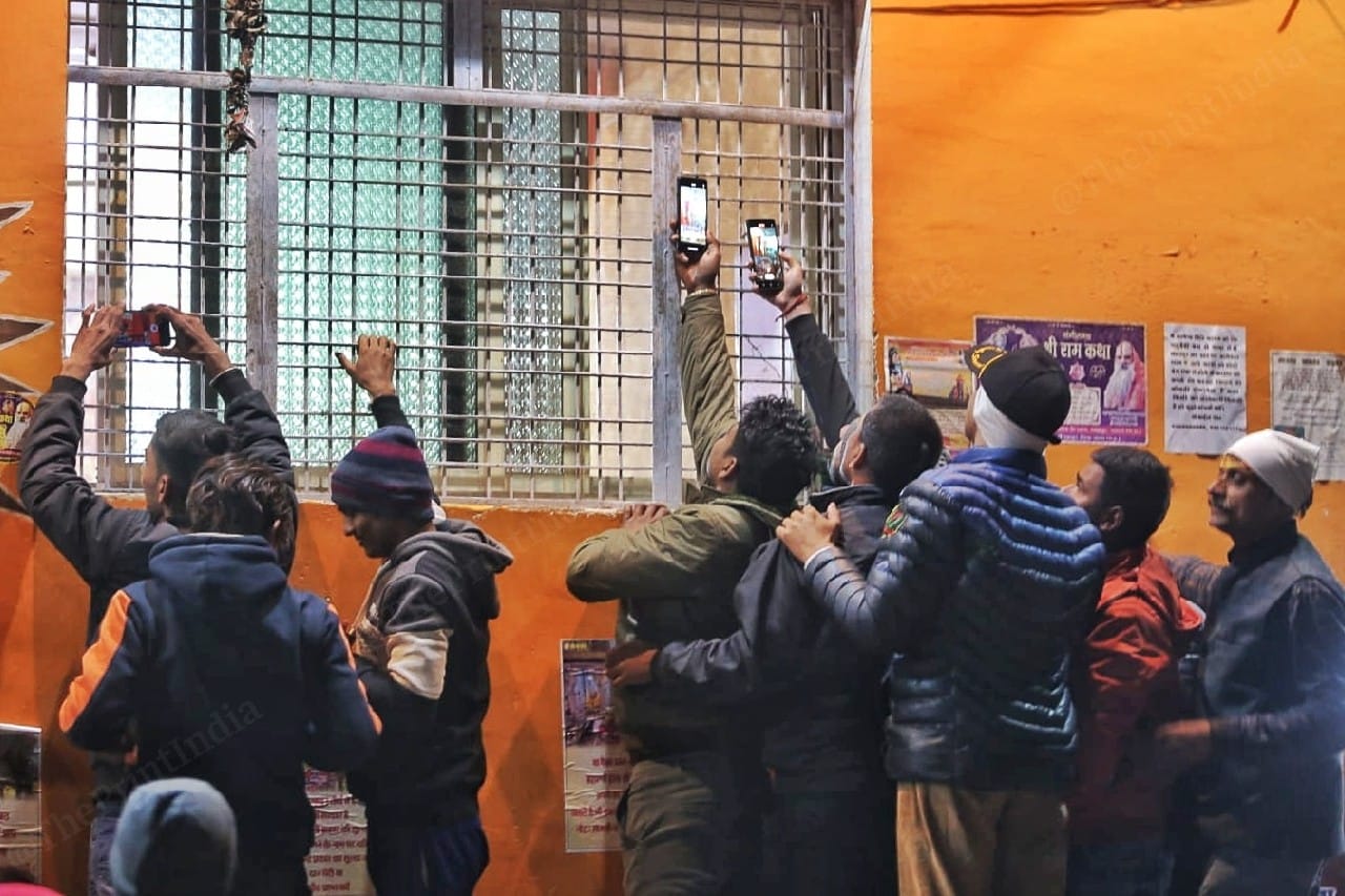 Followers try to click Baba's pictures from outside the darbar | Photo: Praveen Jain | ThePrint