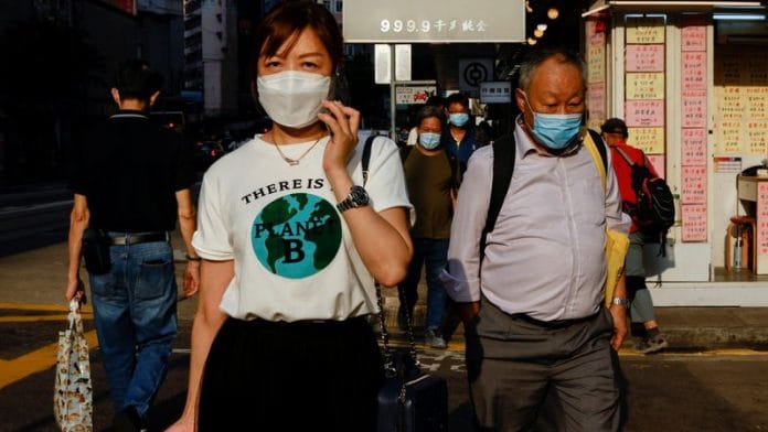 People wearing face masks walk through Wan Chai during the Covid-19 pandemic in Hong Kong, China, on 14 April, 2022 | File Photo: Reuters