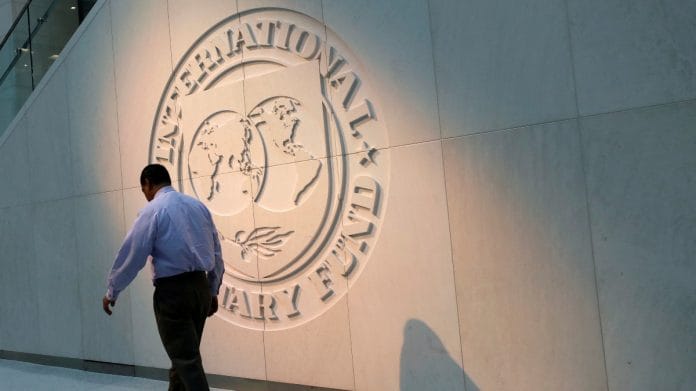 A man walks past the International Monetary Fund (IMF) logo at its headquarters in Washington | Reuters file photo
