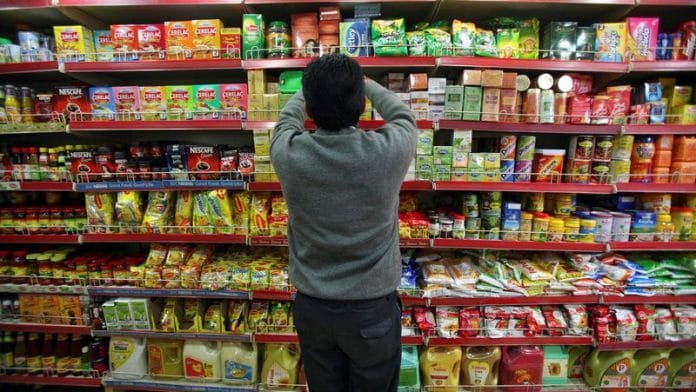 A worker arranges consumable goods at a grocery store in Jammu | File Photo: Reuters