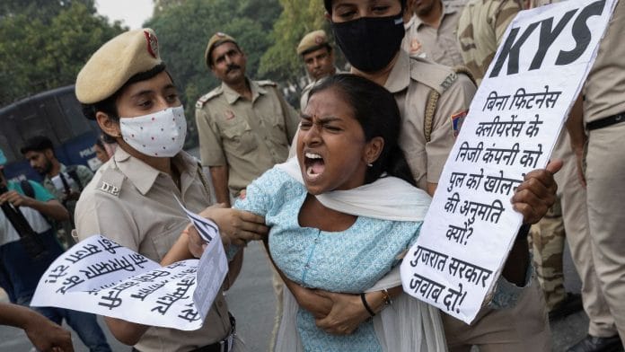 Police restrain a demonstrator during a protest demanding the resignation of Gujarat CM Bhupendra Patel in New Delhi | Reuters file photo