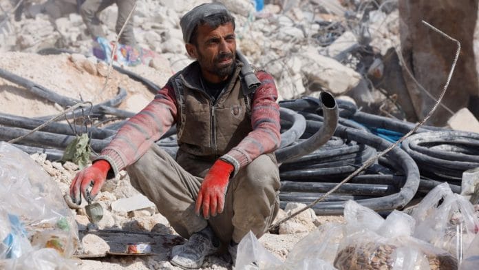 A man sits atop rubble, in the aftermath of a deadly earthquake in the rebel-held town of Harem, in Idlib governorate, Syria, 14 February 2023 Reuters/Emilie Madi