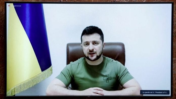 Ukrainian President Volodymyr Zelenskiy appears on a screen as he addresses French lawmakers via video link, amid Russia's invasion of Ukraine, at the National Assembly in Paris on 23 March, 2022 | Reuters