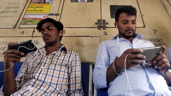 Commuters watch videos on their mobile phones as they travel in a suburban train in Mumbai | Representational image | Reuters Commuters watch videos on their mobile phones as they travel in a suburban train in Mumbai | Representational image | Reuters
