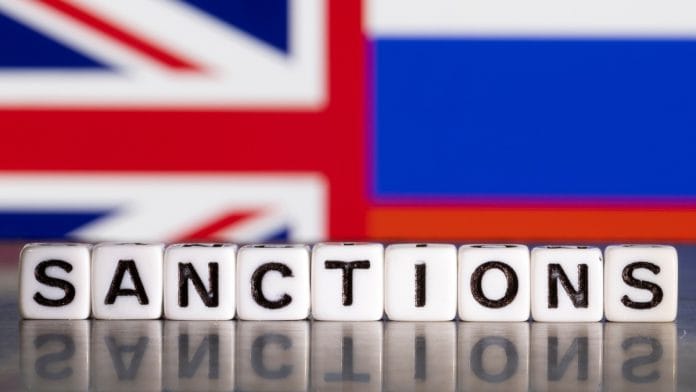 Plastic letters arranged to read 'Sanctions' are placed in front of the Union Jack and Russian flag colours in this illustration | Reuters