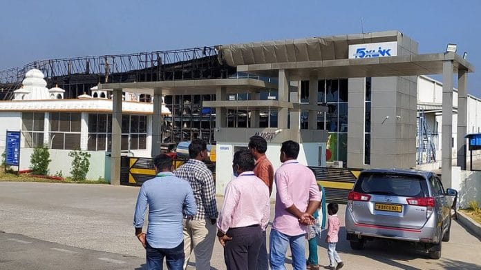 People stand outside Apple supplier Foxlink's assembly facility, after a fire broke out at the facility on Monday in Andhra Pradesh on 28 February, 2023 | Reuters