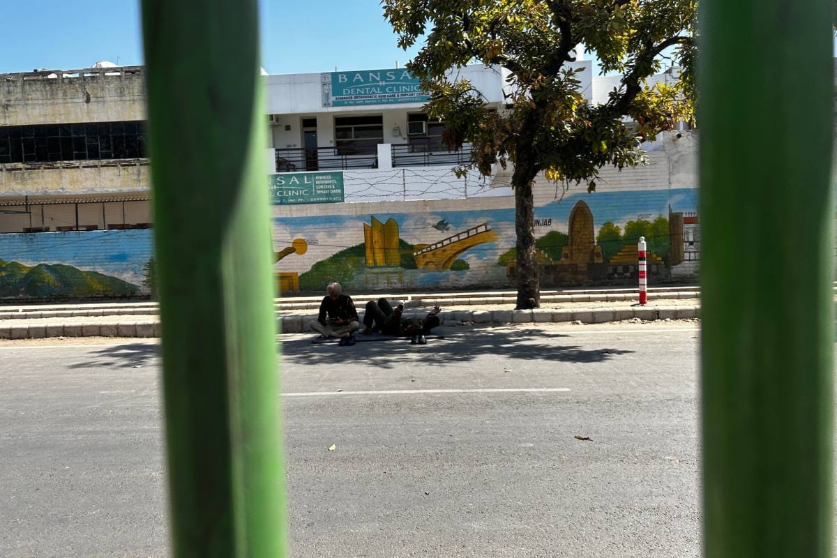 Two policemen rest on the other side of the road on Saturday | Jyoti Yadav | ThePrint