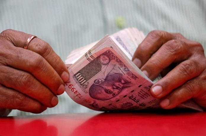 A man counts Indian currency notes inside a shop in Mumbai, India, August 13, 2018. REUTERS/Francis Mascarenhas