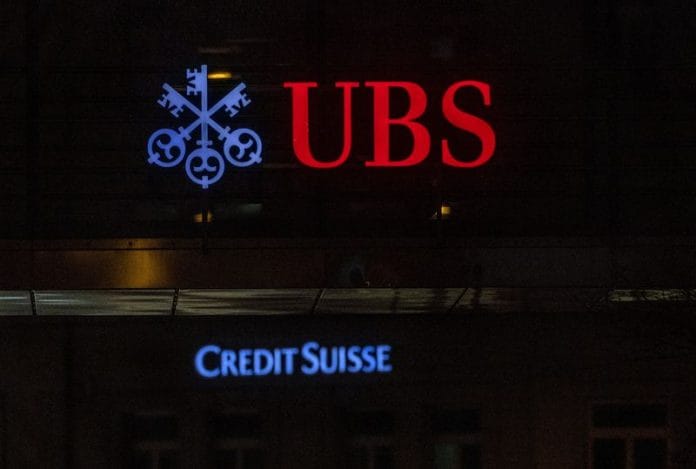 Logos of Swiss banks UBS and Credit Suisse are seen on an office building in Zurich, Switzerland | Reuters