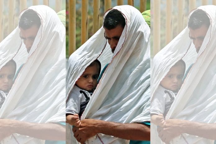 File photo of a man covering himself and his child from the scorching sun in New Delhi | ANI