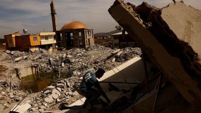 Ibrahim Kurt helps salvage belongings from a collapsed home in the aftermath of a deadly earthquake in Nurdagi, Turkey on 5 March, 2023 | Reuters
