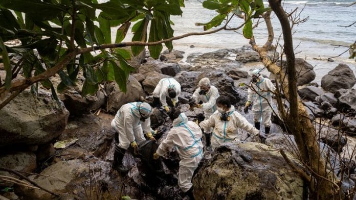 Volunteers dressed in personal protective equipment clean up the oil spill from the sunken fuel tanker MT Princess Empress, on the shore of Pola, in Oriental Mindoro province, Philippines on 7 March, 2023 | Reuters