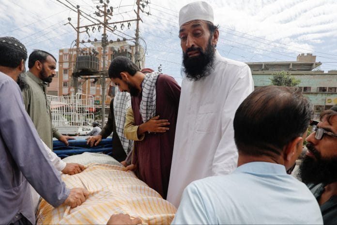 Umer Zada, father of seven year-old Saad Umer, who was killed with others in a stampede during handout distribution, mourns the death of his son during the funeral in Karachi, Pakistan 1 April | Reuters