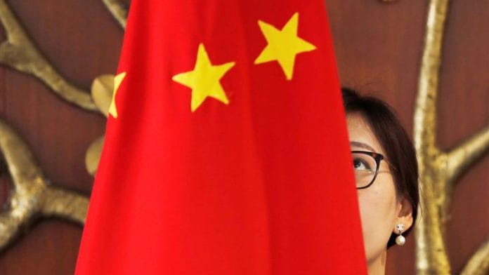 A Chinese official adjusts a Chinese flag before the start of a meeting between Foreign Minister Wang Yi and Indian Foreign Minister Sushma Swaraj in New Delhi | File Photo: Reuters
