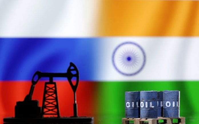 A model of an oil pump jack and oil barrels are seen in front of Russian and Indian flags in this illustration | Reuters