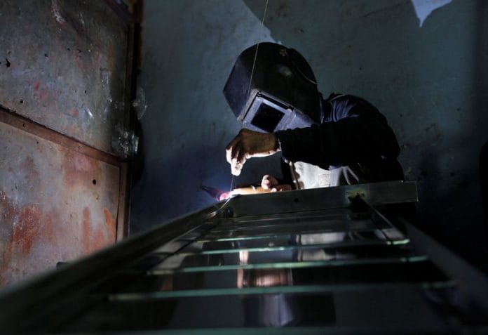 A worker welds steel pipes to make a counter at a steel furniture manufacturing unit in Ahmedabad | Reuters file photo