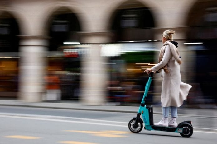 A woman rides an electric scooter by Tier sharing service, on the eve of a public vote on whether or not to ban rental electric scooters in Paris | Reuters