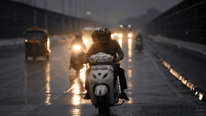 People commute during rainfall, in New Delhi, Sunday | ANI