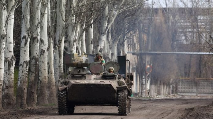 An armoured military vehicle speeds through Chasiv Yar during heavy fighting at the fronttline of Bakhmut and Chasiv Yar, Ukraine, on 9 April, 2023 | Reuters