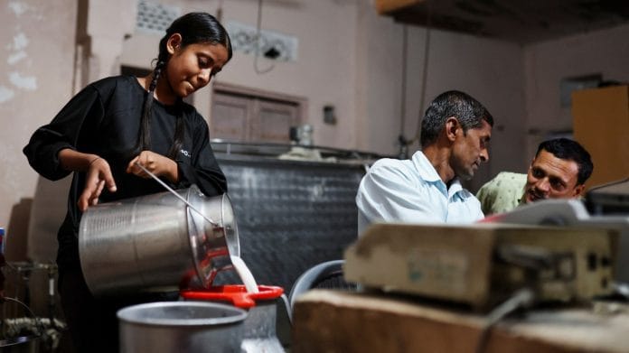A girl pours milk into a container at a milk collection centre on the outskirts of Jaipur | Reuters