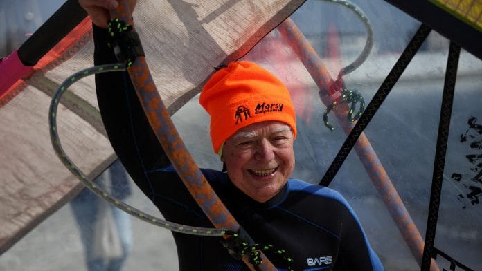 Piotr Dudek carries a sail before windsurfing in Gdynia, Poland on 18 April 2023 | Photo: REUTERS