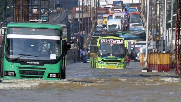 Traffic moves through a water-logged road following torrential rains in Bengaluru | File Photo: Reuters