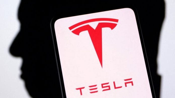 Tesla logo and Elon Musk silhouette are seen in this illustration | Reuters