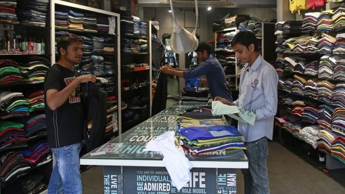 Salesmen fold shirts inside a clothes store at a market in Mumbai | File Photo: Reuters