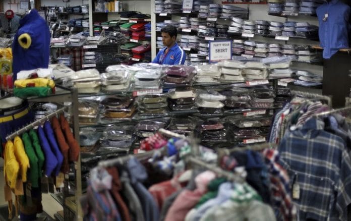 A salesman waits for customers inside a retail store in New Delhi | Photo: Reuters
