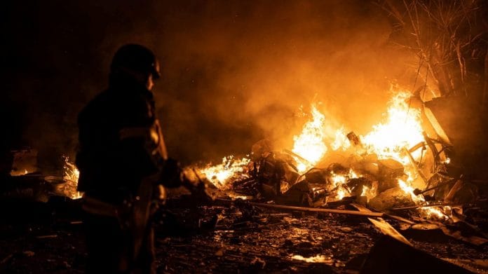 A firefighter works at a site of a vehicle parking area damaged by remains of Russian missiles in Kyiv, on 16 May 2023 | Reuters