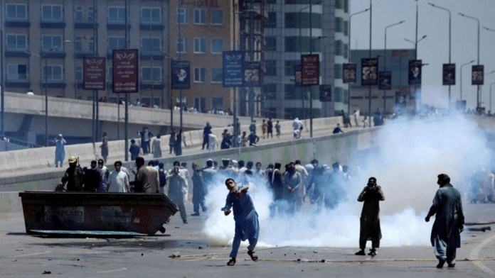 Supporters of Pakistan's former PM Imran Khan throw stones at police during a protest against Khan's arrest, in Peshawar, Pakistan, | Reuters/Fayaz Aziz