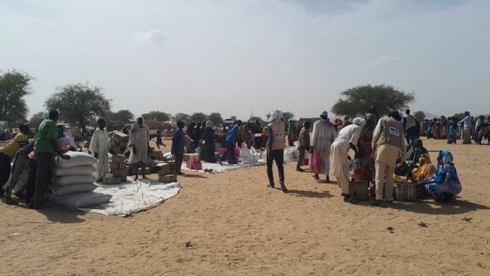 udanese refugees who fled the violence in their country, gather for food given by the World Food Programme (WFP) near the border between Sudan and Chad, in Koufroun, Chad | Reuters