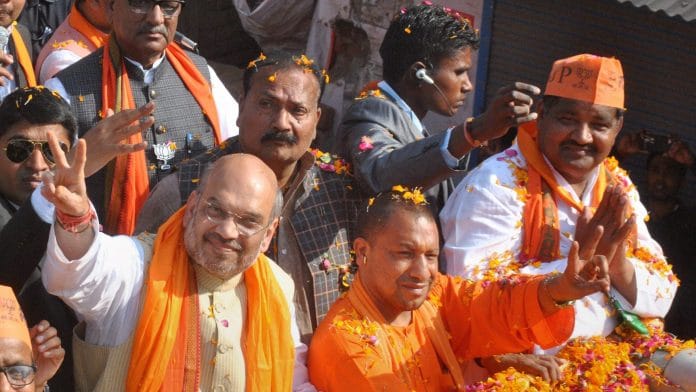 Gorakhpur : Home Minister Amit Shah with UP CM Yogi Aditya Nath during an election road show in Gorakhpur district on Thursday. PTI Photo (PTI3_2_2017_000227B)