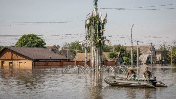 Volunteers sail on a boat during an evacuation of local residents from a flooded area after the Nova Kakhovka dam breached, amid Russia's attack on Ukraine in Kherson | Reuters