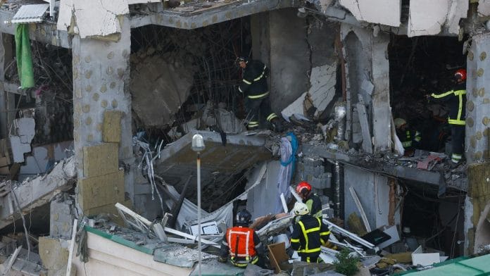 Rescuers work at the site of an apartment building damaged during Russian missile strikes, amid Russia’s attack on Ukraine, in Kyiv | Reuters