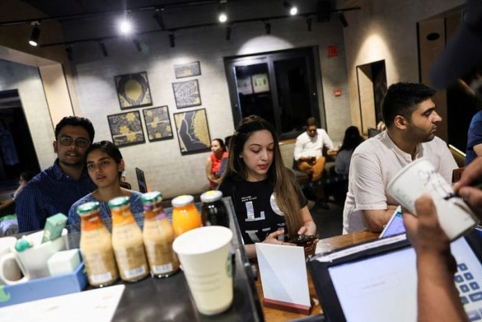 Customers stand next to a counter at a Starbucks' outlet at a market in New Delhi, India, May 30, 2023 | REUTERS/Anushree Fadnavis