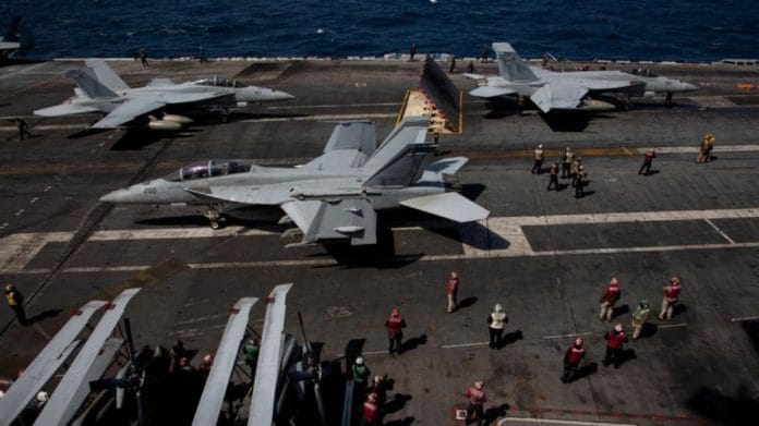 U.S. navy F-18 Super Hornet and crews are seen on the flight deck on the USS Nimitz, off the coast of Busan, South Korea, 27 March 2023/Reuters