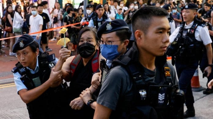 Police detain a woman with paper flowers on the 34th anniversary of the 1989 Beijing's Tiananmen Square crackdown in Hong Kong | Reuters/Tyrone Siu
