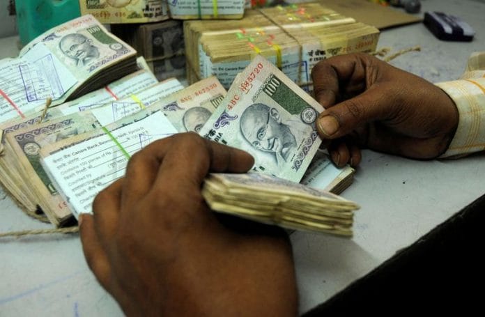 An employee counts currency notes at a cash counter inside a bank in Agartala | Reuters file photo