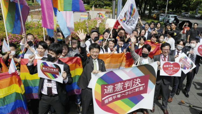 People hold banners & flags, after the lower court ruled that not allowing same-sex marriage was unconstitutional, outside Nagoya district court, in Nagoya, central Japan | Kyodo via Reuters