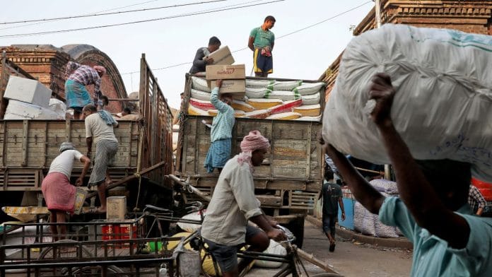 Labourers load consumer goods onto supply trucks at a wholesale market in Kolkata, India, December 14, 2021 | Reuters/Rupak De Chowdhuri/File photo