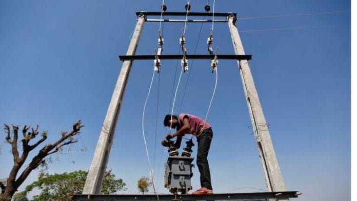A man installs an electric transformer outside a wheat field on the outskirts of Ahmedabad | Reuters file photo