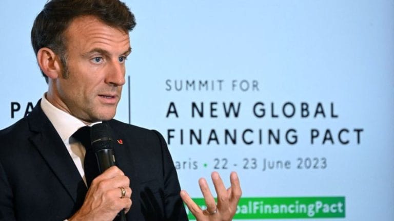 Emmanuel Macron says wealthy nations have pledged $100 billion climate aid at Paris summit