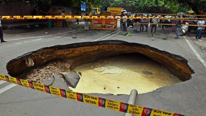 Police demarcated the area where a large portion of the road has caved in due to heavy rainfall, at Janakpuri, in New Delhi on Wednesday | ANI