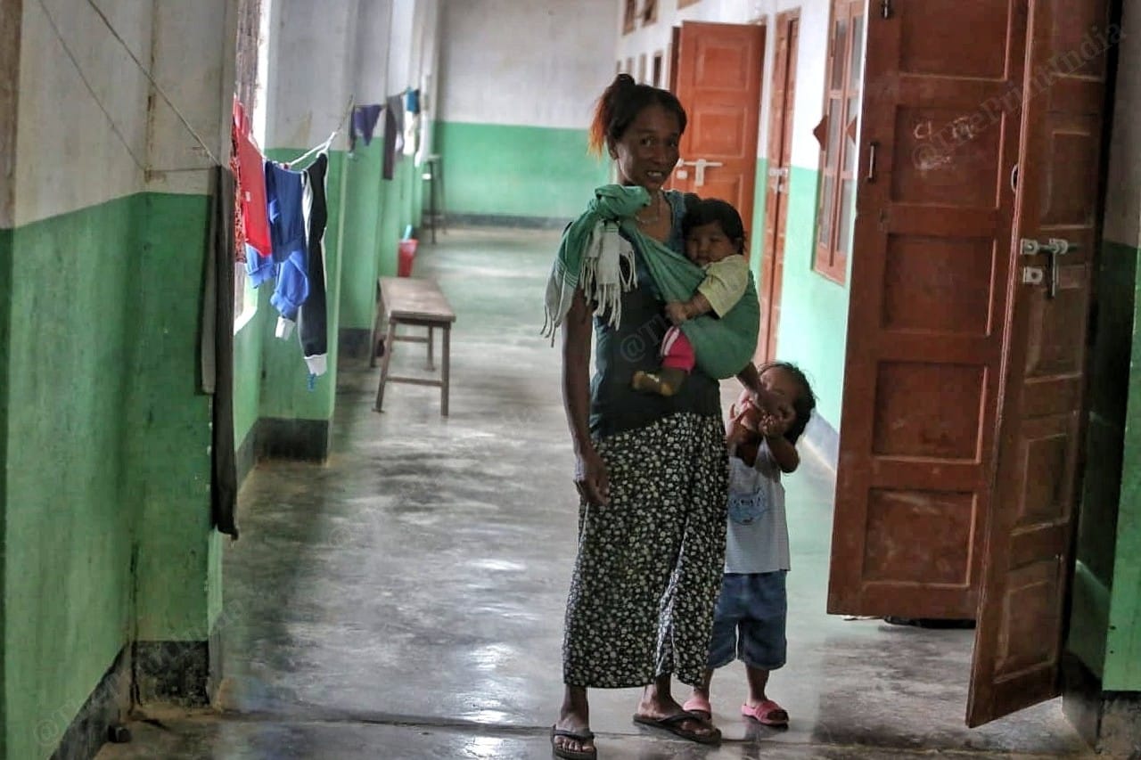 A Kuki woman wraps toddler around her while the older one cries for attention from mother. Photo: Praveen Jain | ThePrint