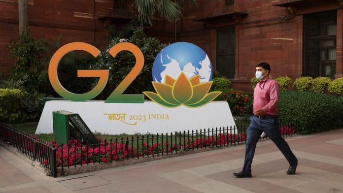 A man walks past a model of G20 logo outside the finance ministry in New Delhi | File Photo: Reuters