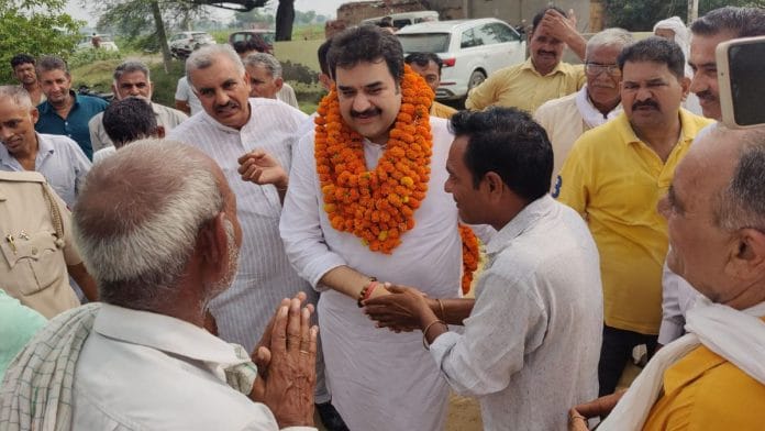 Haryana BJP leader Kuldeep Bishnoi with voters in Adampur Friday | By special arrangement