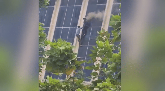 Two people were seen hanging from a window on the third floor of the Galaxy Plaza. (Credit: Twitter)