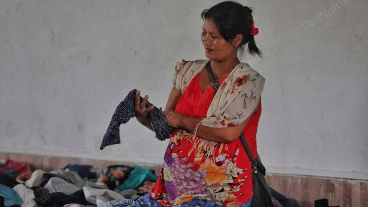 Thethiem rummages through a pile of old, worn-out clothes | Praveen Jain | ThePrint