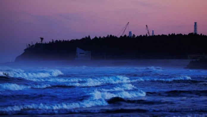 Ventilation stacks and cranes at the disabled Fukushima Dai-ichi nuclear power plant are seen from a beach in Namie, Japan | Reuters file photo